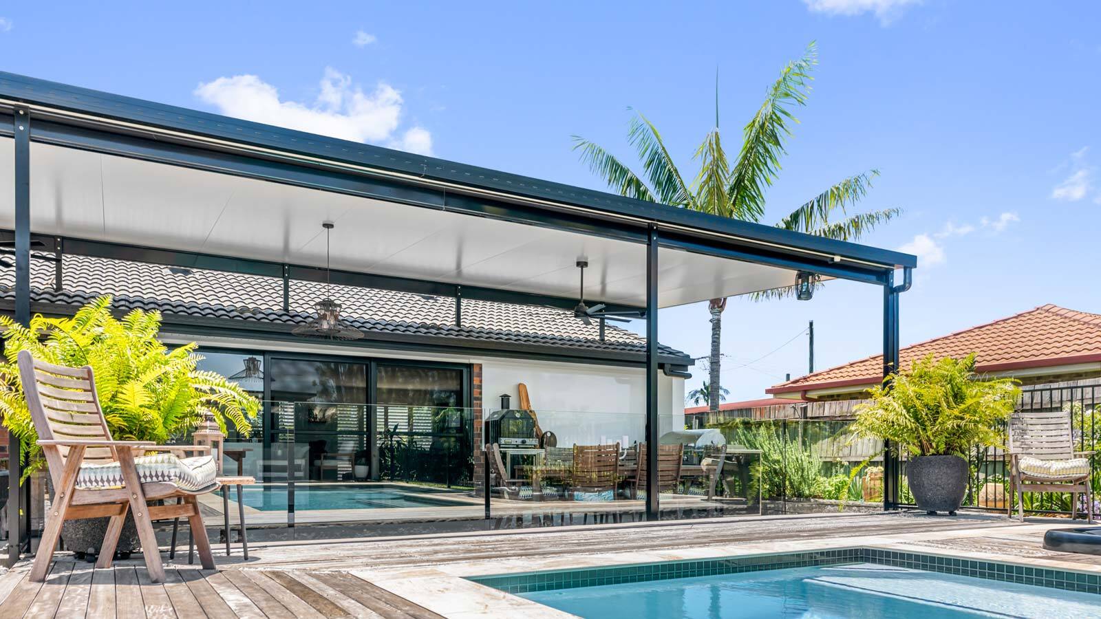 Altec patio with insulated roof beside a pool and glass fencing