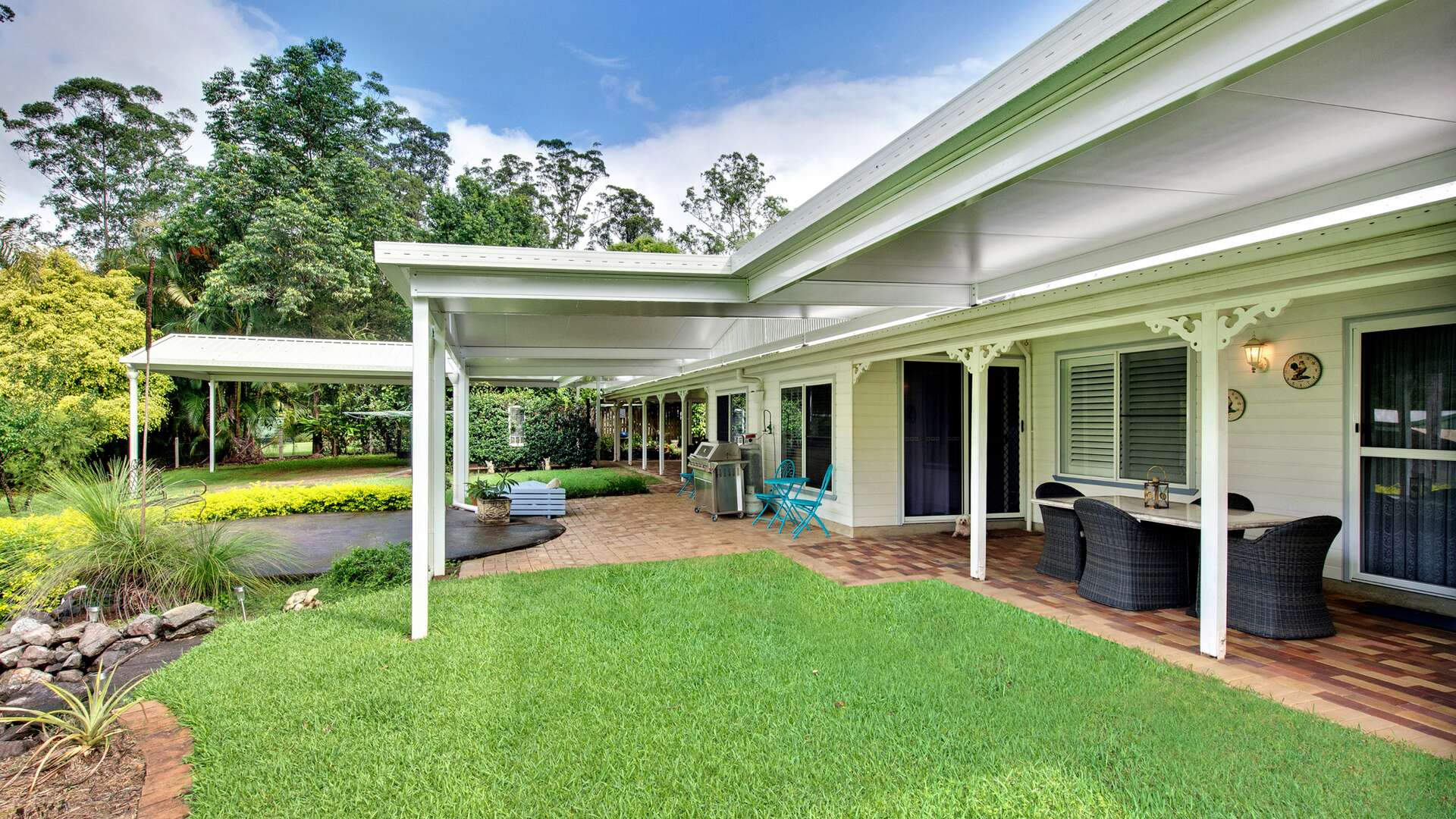 A outside patio, white facade with multiple styles of patio products.